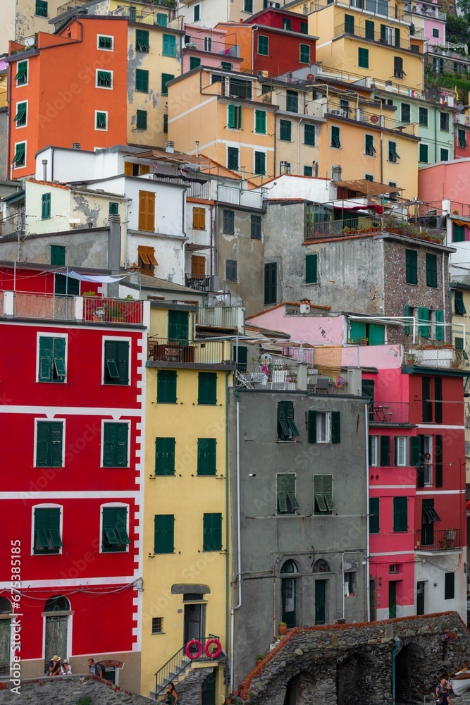 Village with narrow streets lined with brightly painted red and yellow houses in Riomaggiore, Italy