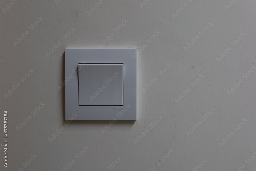 white light switch on the wall. It is turned on. white light switch on the wall. It is turned on.
