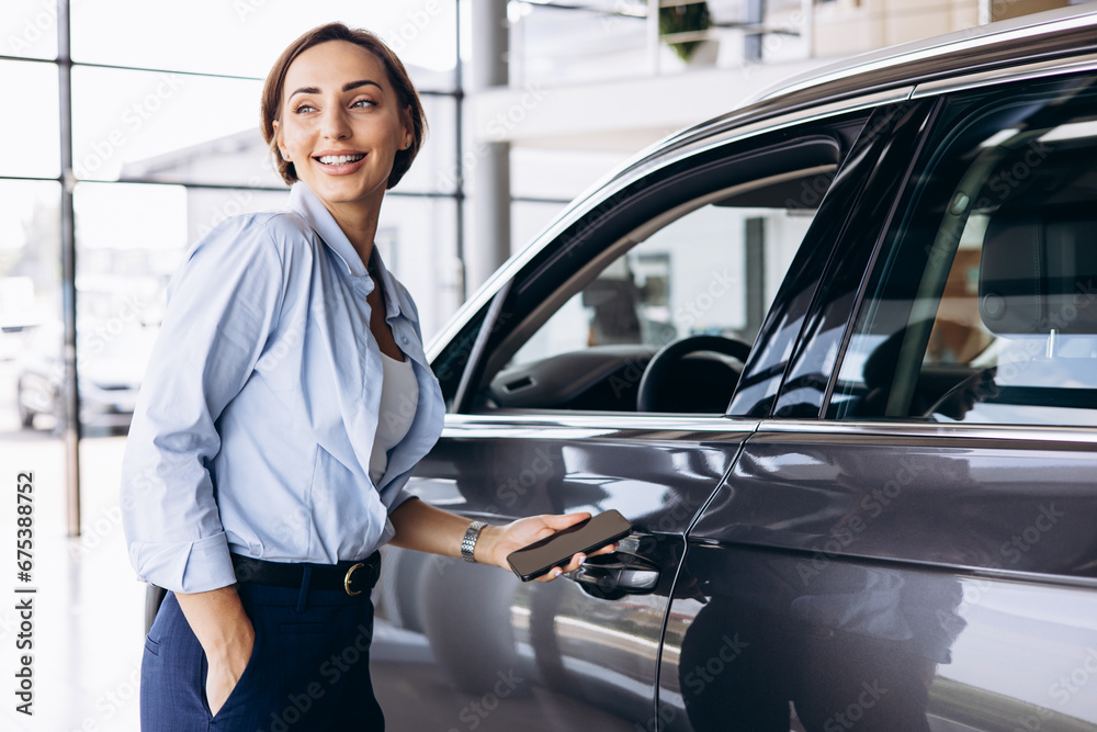 Woman standing by her new car and holding car keys