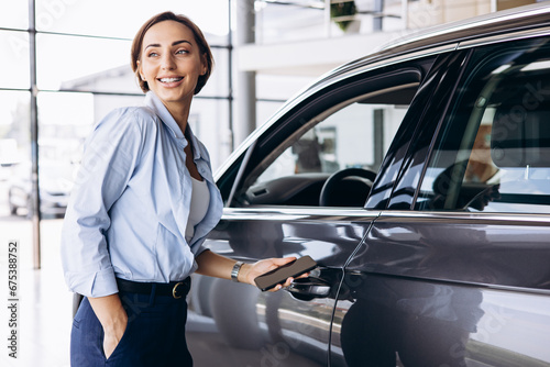 Woman standing by her new car and holding car keys