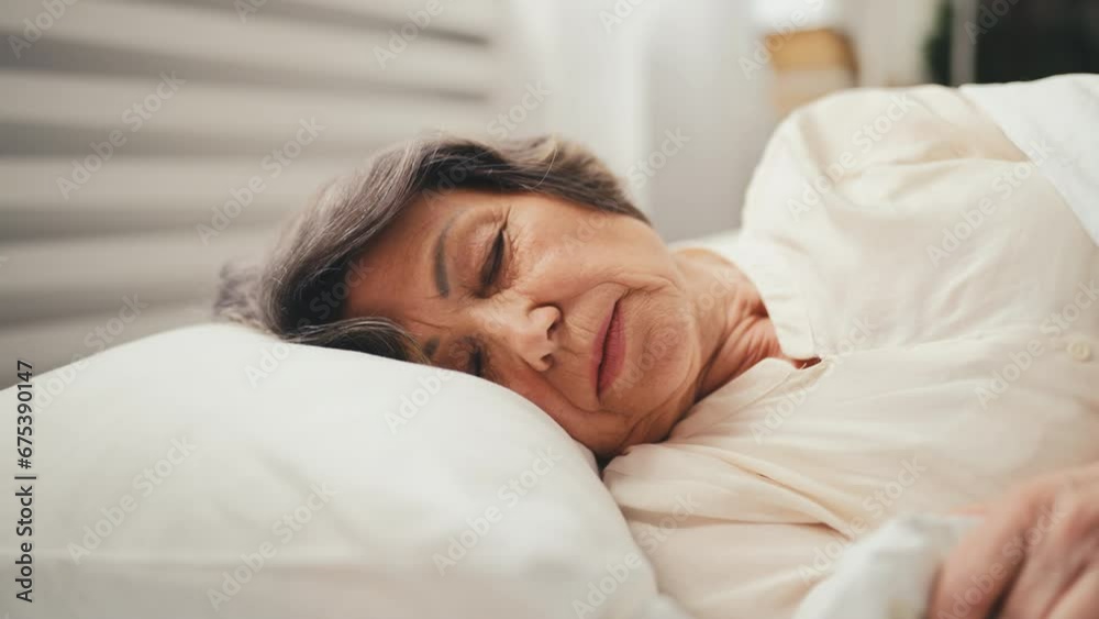 Senior woman lying on orthopedic pillow in the morning, healthy sleep cycle Senior woman lying on orthopedic pillow in the morning, healthy sleep cycle