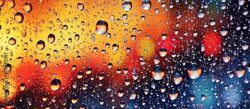 As the raindrops fell they created a mesmerizing splash on the window s glass showcasing a shiny abstract pattern against the white background resembling the beautiful and vibrant textures 