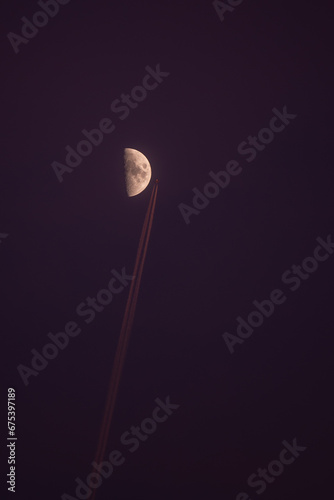 Domestic plane flying close to the moon. The natural satellite of the earth in the first quadrant