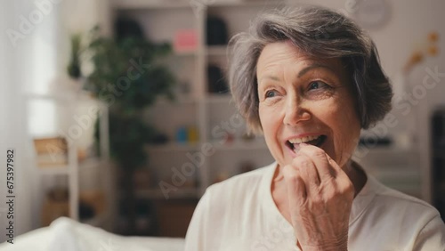 Smiling senior woman taking pills with water, health support in senior age photo
