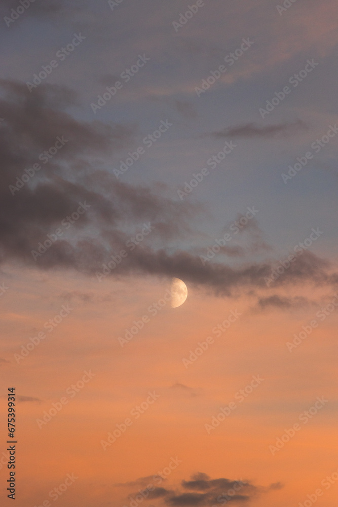 Sky is divided into an upper blue part and a lower orange half, with the crescent moon in the middle during its growth. Space object Sky is divided into an upper blue part and a lower orange half, with the crescent moon in the middle during its growth. Space object