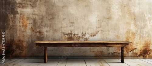 The vintage wood table with an abstract grunge design on its surface adds a unique texture to the overall background complemented by the light reflecting off the white wall and old textured 