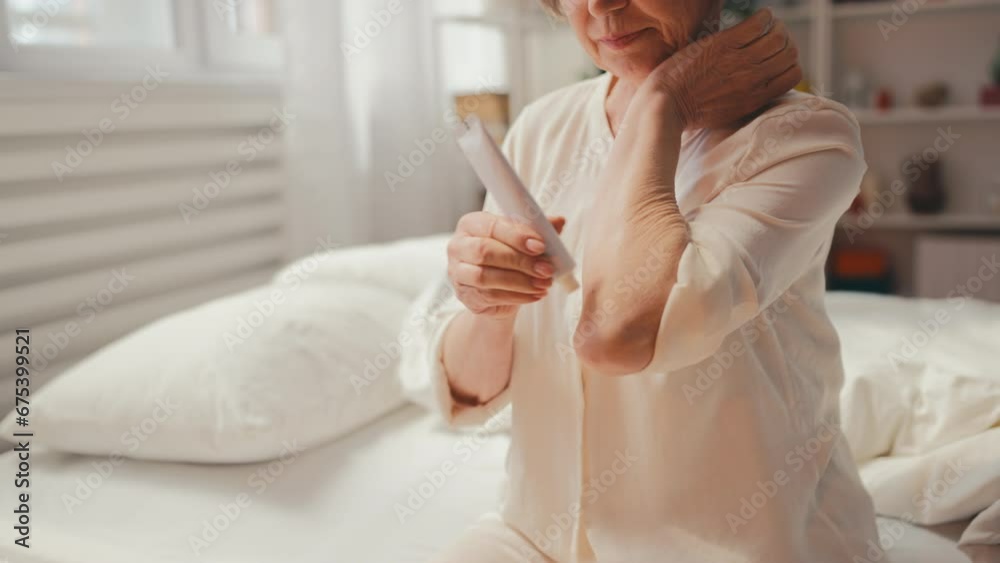 Mature woman putting cream for joints on elbows, arthritis treatment, healthcare Mature woman putting cream for joints on elbows, arthritis treatment, healthcare