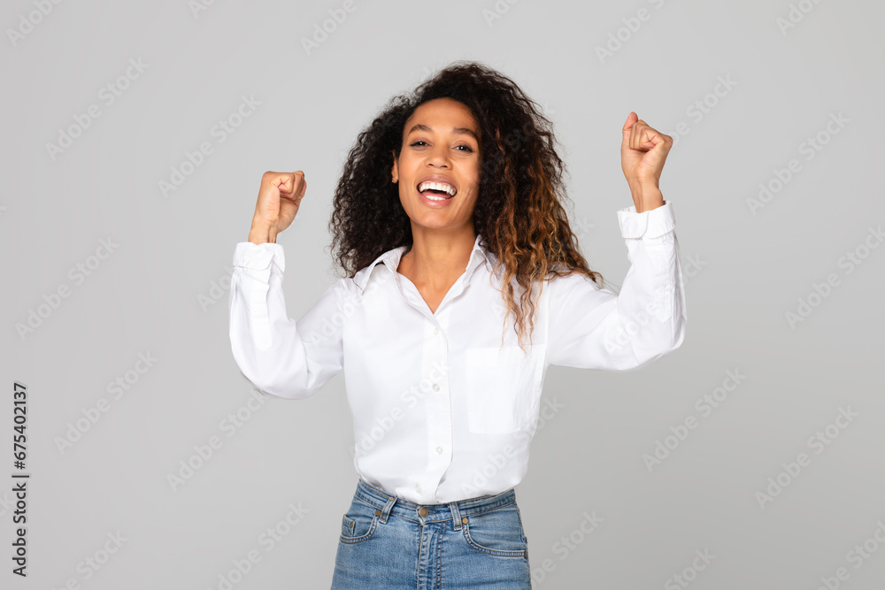 Cheerful African American Woman Shaking Fists Raising Both Hands, Studio Cheerful African American Woman Shaking Fists Raising Both Hands, Studio
