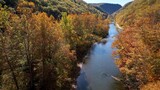 Peaceful Pine Creek flowing through mountains in Autumn Fall colors in trees at The Pennsylvania Grand Canyon vacation destination for sight seeing beautiful countryside in America.