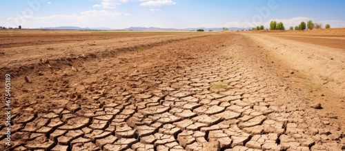 The drought had a devastating effect on the farm causing the ground to crack and the soil to become dry and sandy transforming the once fertile earth into a barren gray backdrop for the str photo