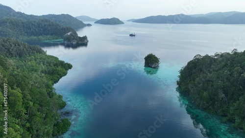 Limestone islands, covered by tropical vegetation, are fringed by coral reefs in the calm Alyui Bay, Raja Ampat, Indonesia. The reefs of this region support the greatest marine biodiversity on Earth. photo