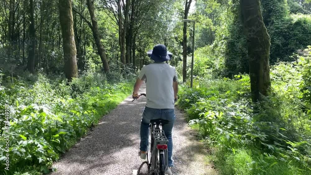 slow motion, a man riding a bicycle in a forest under sunshine slow motion, a man riding a bicycle in a forest under sunshine