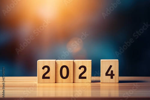 Happy New Year Concept, The upcoming year 2024 is written on wooden cube blocks on the table against a blue background. Copy Space for text, banner or poster photo