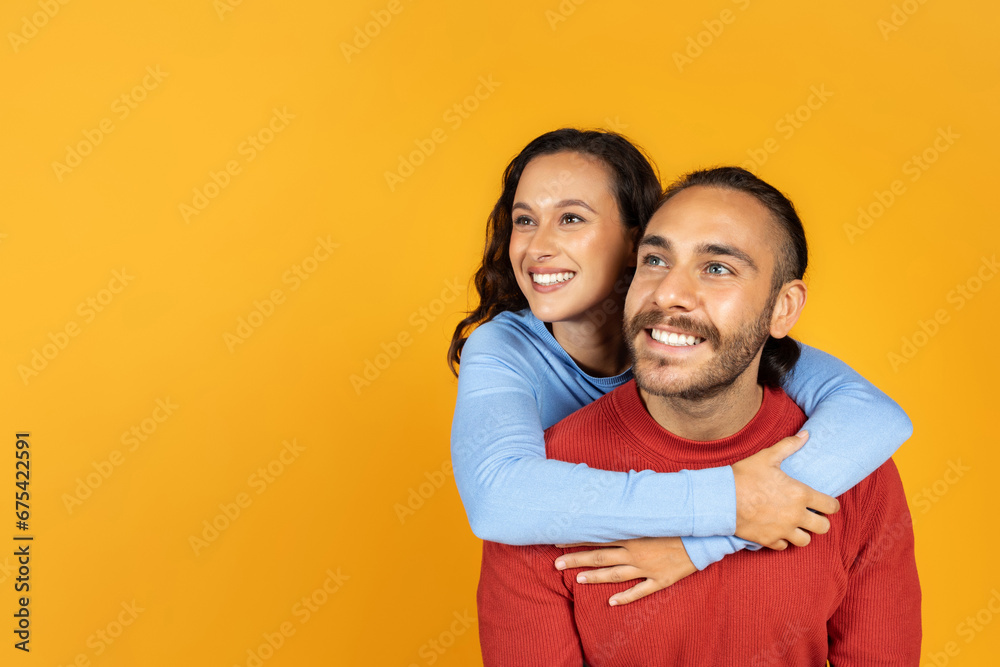 Obraz premium Cheerful young lovers embracing and looking at copy space