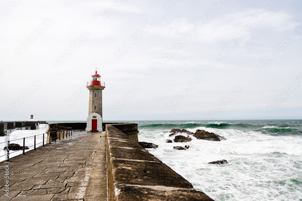 Felgueiras Lighthouse in Porto on the Atlantic coast with huge waves in a sunny day, splashing waves at Farol de Felgueiras
