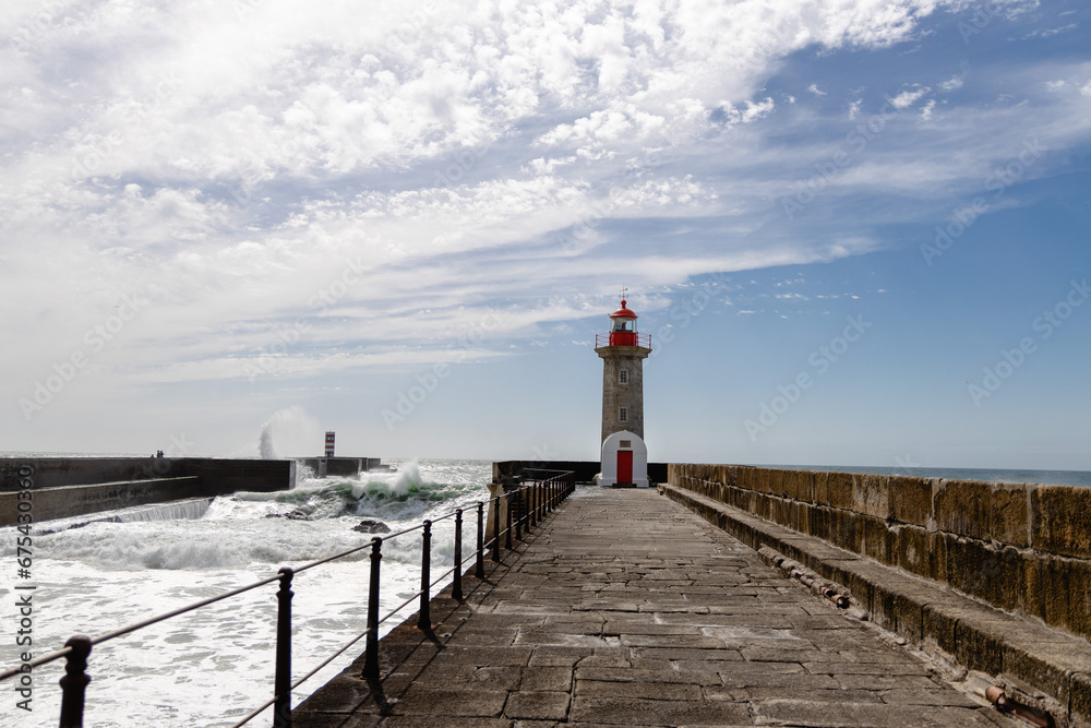 Felgueiras Lighthouse in Porto on the Atlantic coast with huge waves in a sunny day, splashing waves at Farol de Felgueiras