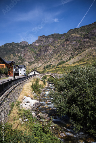 Medieval stone bridge over the river in Espot village in Pyrenees mountains, summer