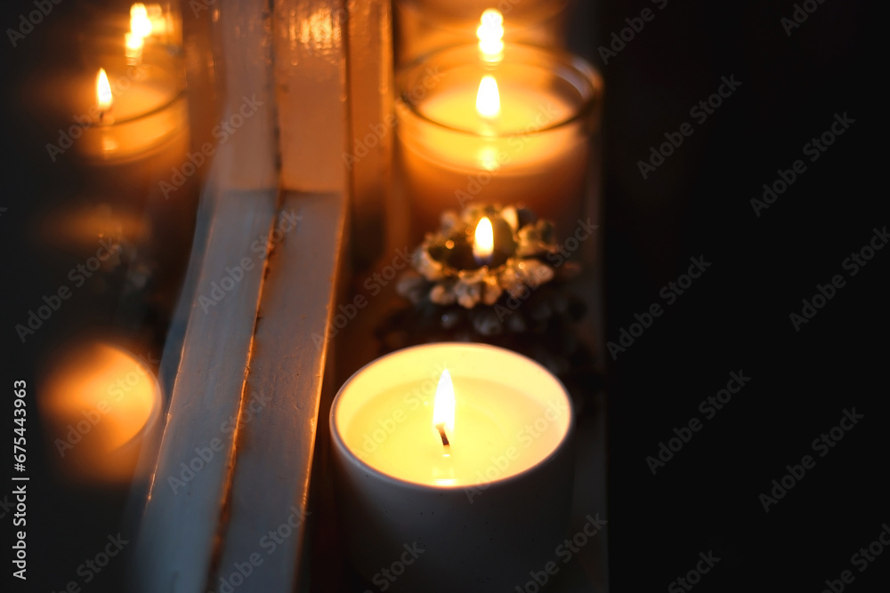 Lit candles and Christmas decorations on the window sill at night. Hygge at home. Selective focus. Lit candles and Christmas decorations on the window sill at night. Hygge at home. Selective focus.