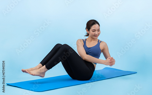 Asian woman in sportswear doing crunch on exercising mat as workout training routine. Attractive girl in pursuit of healthy lifestyle and fit body physique. Studio shot isolated background. Vigorous