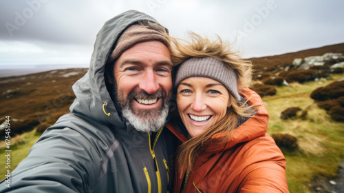 Happy traveling couple making selfie mountains background, sunny summer colors, romantic mood. Happy laughing emotional faces. © PaulShlykov