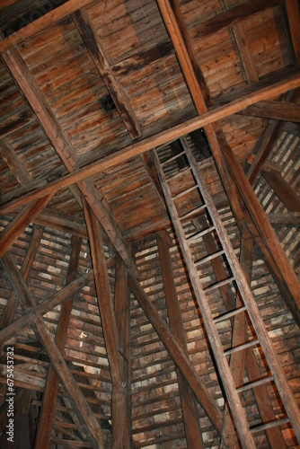 A wooden structure with a ladder running through its center, providing access to different levels or platforms.