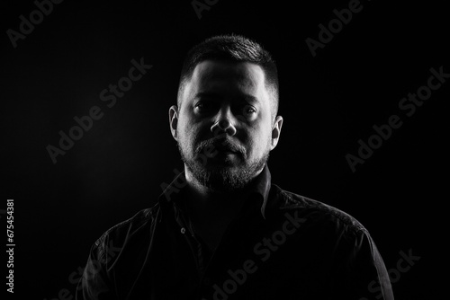 Strict and stylish Man in black shirt on dark background.