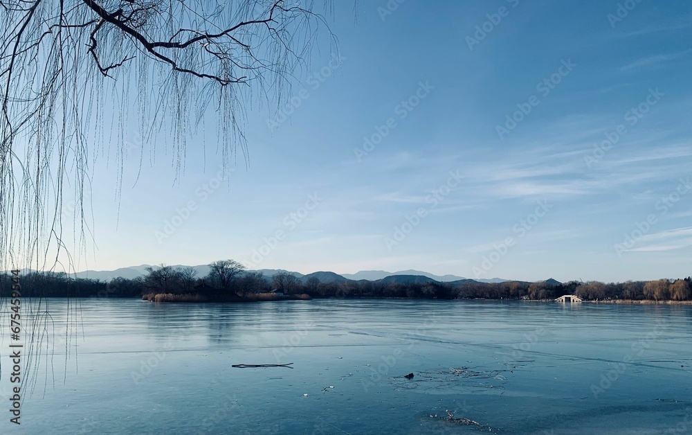 Tranquil winter scene featuring a serene frozen lake with majestic mountains in the background