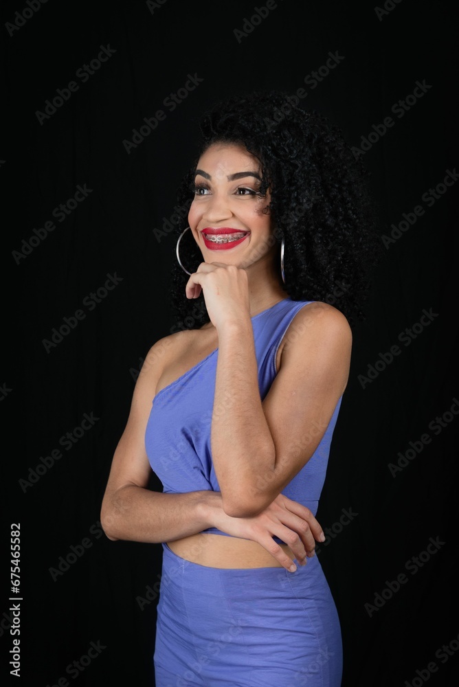 Fototapeta premium Young beautiful smiling woman with hand on chin, wearing blue ou