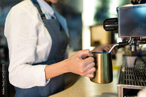 Coffee shop assistant preparing coffee in a coffee store photo