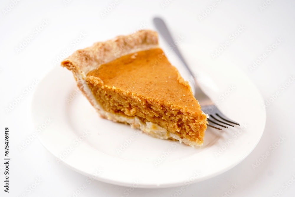 Sliced pumpkin pie isolated on white background, selective focus