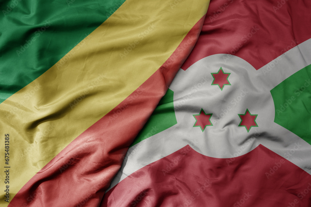 big waving national colorful flag of republic of the congo and national flag of burundi .