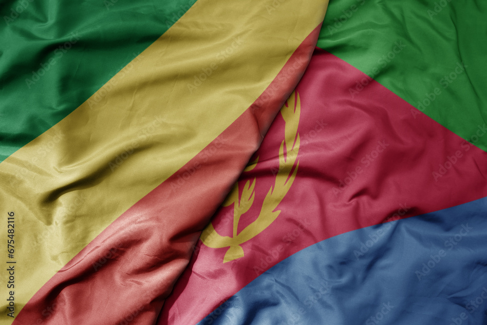 big waving national colorful flag of republic of the congo and national flag of eritrea .