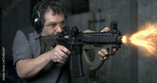 Man aiming and firing an assault rifle in high-speed 800 fps. Shooting with CQR Gun in super slow-motion with bullets flying in the air © Marco