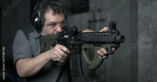 Man aiming and firing an assault rifle in high-speed 800 fps. Shooting with CQR Gun in super slow-motion with bullets flying in the air
