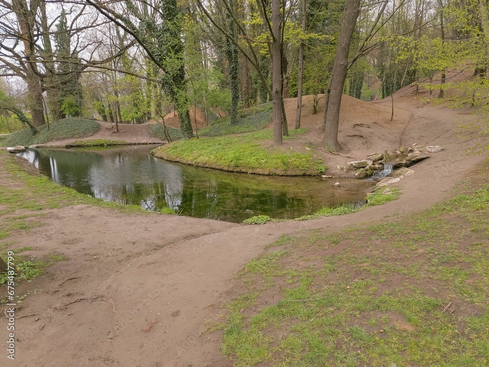 the small river in the middle of a grassy hill beside trees the small river in the middle of a grassy hill beside trees