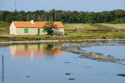 old stone house on the lake reflecting in the water on the West coast of France
