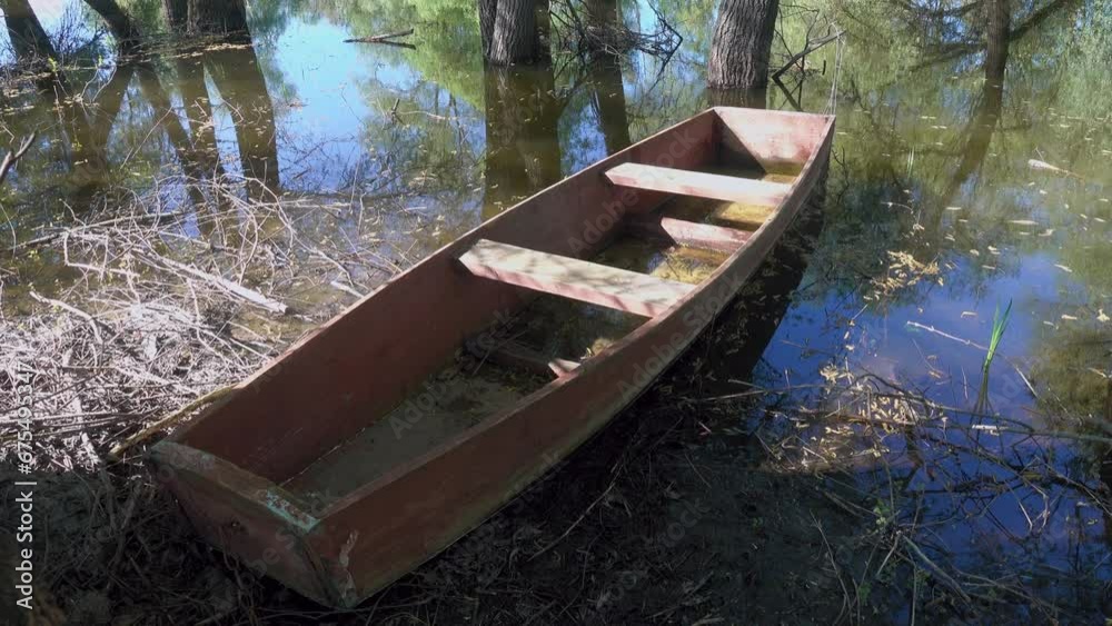 Old style boat, primitive box-shaped wooden boat for sailing in small inland reservoirs on the banks of the dead arm of river and floodplain forest. Don River. Russia Old style boat, primitive box-shaped wooden boat for sailing in small inland reservoirs on the banks of the dead arm of river and floodplain forest. Don River. Russia