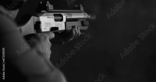 Monochrome shot of person firing a powerful shotgun and reloading shell bullet in black and white