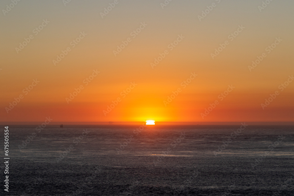 sunset over the pacific ocean, image shows the final moments of the sun setting over the san fancisco bay, california lighting up the sea and sky with various colours, taken october 2023