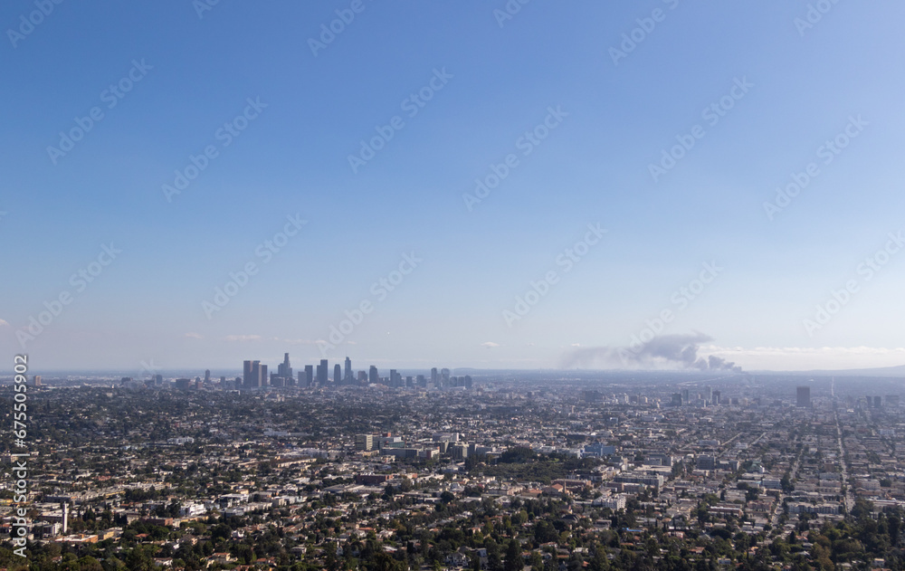 view of los angeles from the griffith observatory, image shows a cityscape view with a warehouse fire from the observatory on a hot autumns day in california, taken october 2023