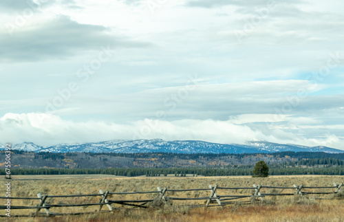 snow covered mountains in yellowstone, image shows a landscape image of the countryside, including forests at the base of the mountain and the snow covered mountain with dark clouds taken october 2023