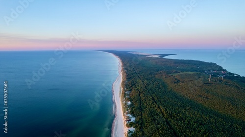 Curonian Spit National Park at sunset, aerial shot. A narrow and long sandy strip of land separating the Curonian Lagoon from the Baltic Sea. Forest and sea. Drone view