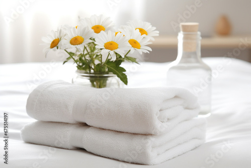 The close up detail of a neatly flooded white bath towel placed on a bed near the flower vase in a hotel room. Generative AI.