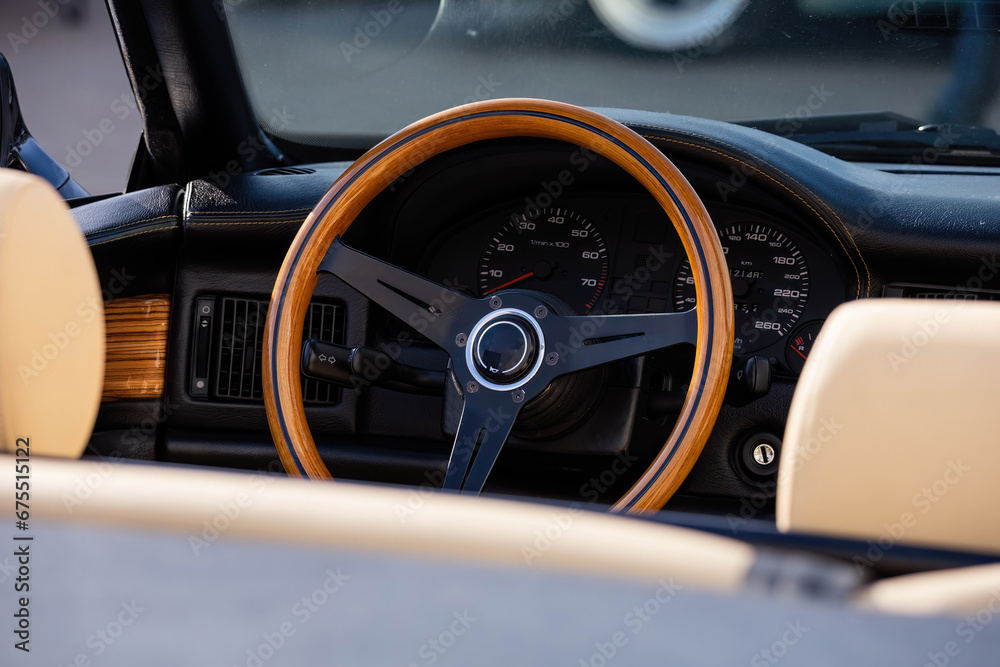 wooden steering wheel in car. Car interior with dashboard, speedometer and tachometer