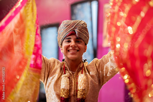 young indian teenager looking at camera while holding bollywood dance veils photo