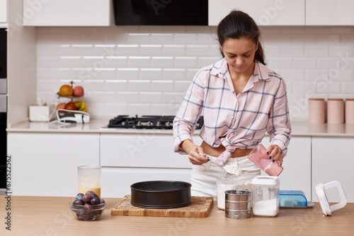 pretty woman preparing dough for pie in modern kitchen