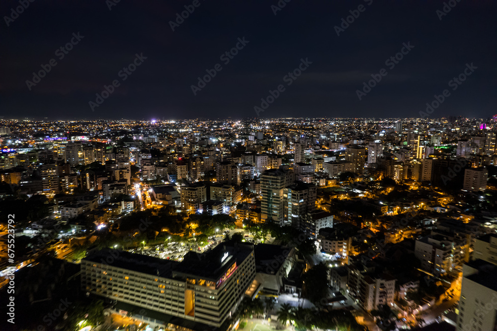Beautiful aerial Night view of the illuminated  city of Santo Domingo - Dominican Republic with is Parks, buildings, suburbs ,turquoise Caribbean ocean, parks and malecon