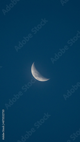 waning moon in a blue sky photo
