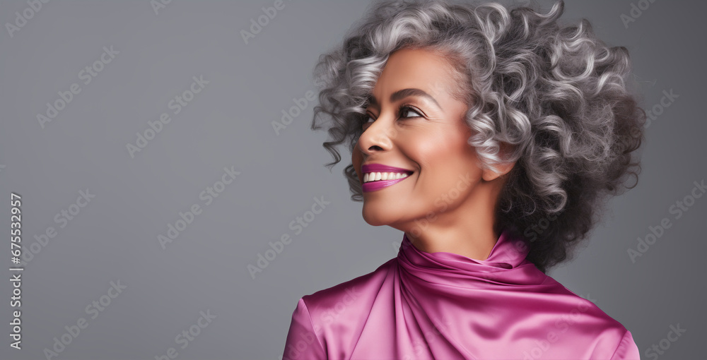Black adult woman touch face with smooth healthy skin. Beautiful aging mature woman with long gray hair and happy shy smiling. Beauty and cosmetics skincare advertising concept