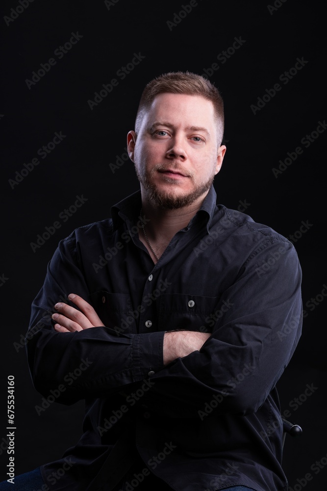 Obraz premium Strict and stylish Man in black shirt on dark background.